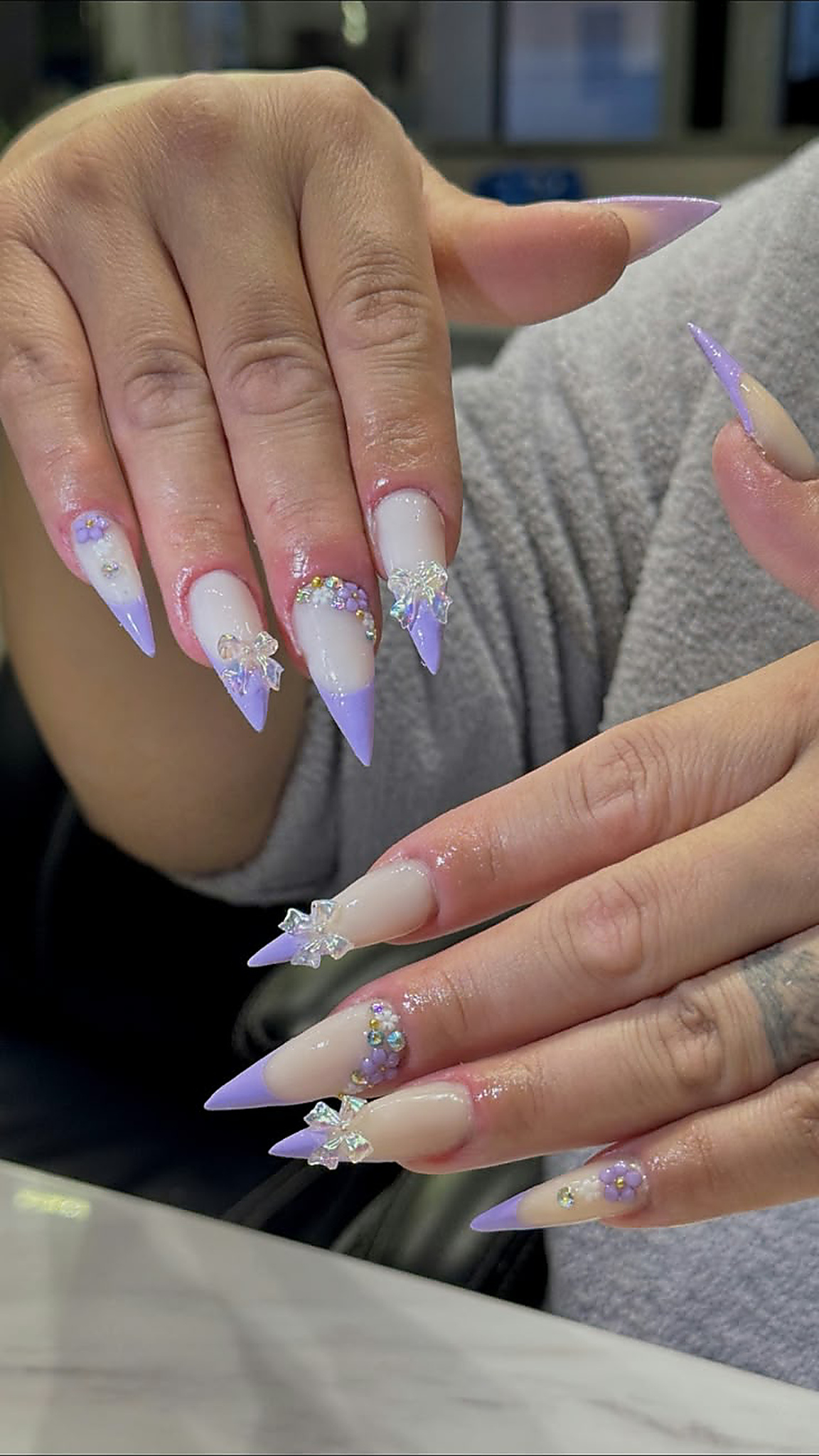 Long nails with lilac French tips, 3D bows, lavender flowers and pearl details